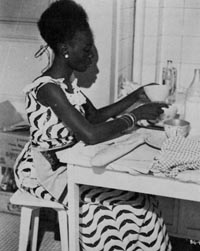 Diouana, dressed for a 'glamorous' life in France, but spending her time in the kitchen