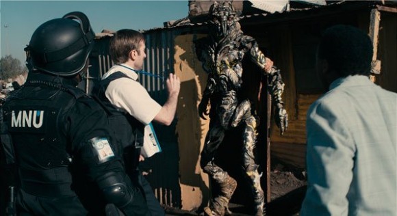 Wickus Van der Merwe from MNU attempts to persuade an alien to sign his eviction notice from District 9