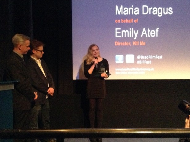 Maria Dragas, star of 'Kill Me' speaking after receiving the European Features award on behalf of Emily Latef – watched by Tom Vincent and Neil Young, Festival Directors.