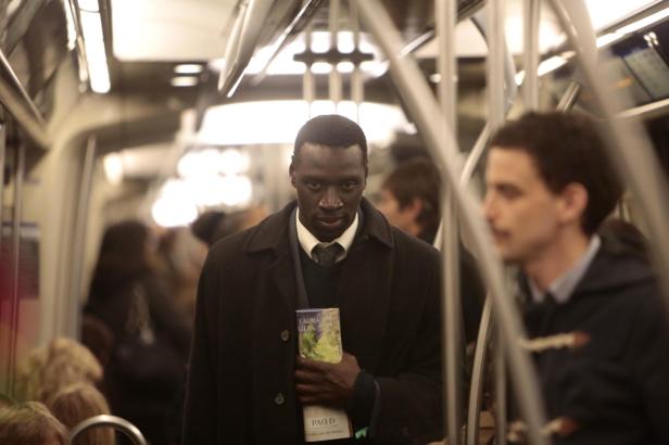 Omar tries to 'disguise' his identity with suit and tie and briefcase to avoid random police checks.