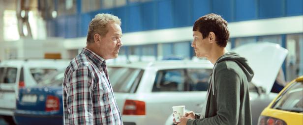 Sandu Patrescu (Theodor Corban, left) confronts his neighbour (Iulian Postelnicu) who has commissioned him to undertake a seemingly meaningless change of vehicle registration.