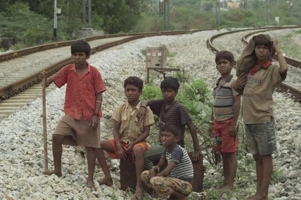 The local boys waiting to ambush a train. The stick is used to knock the mobile phones out of the hands of passengers sat by open doorways.