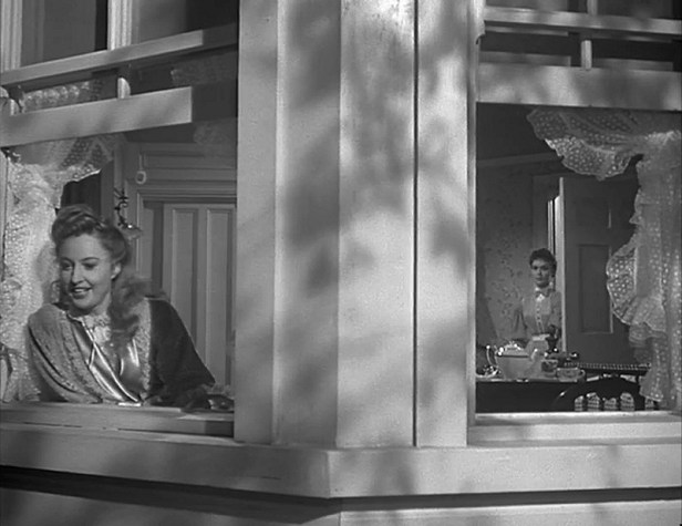 Expression through composition. Naomi looks out, excited to see her daughter's boyfriend come to take them riding. Joyce, the reproachful daughter looks on from the back of the room, separated from her mother by the window jamb.