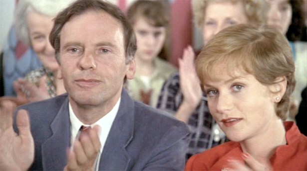 Vic (Jean-Louis Trintignant) and Mélanie (Isabelle Hupert) watch their daughter at a piano recital at school